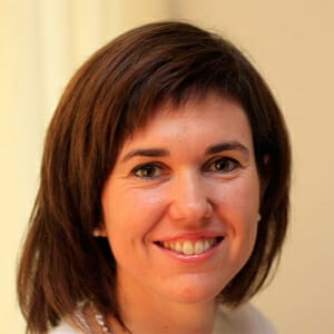 Een vrouw met bruin haar die haar stralende glimlach laat zien.